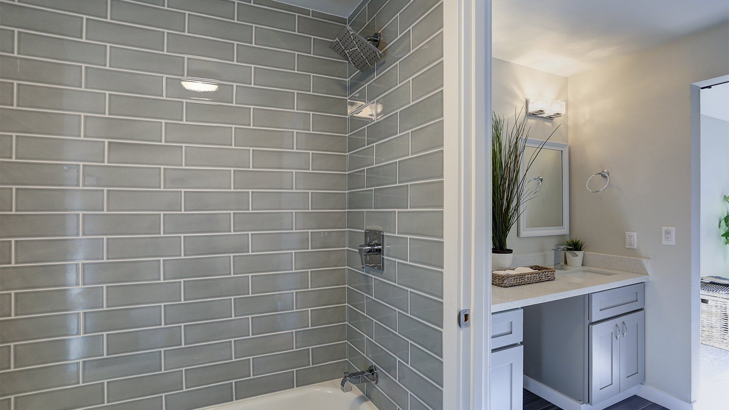 bathroom with gray shower wall tiles